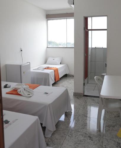 a hotel room with two beds and a bathroom at Hotel Cco Goiânia in Goiânia