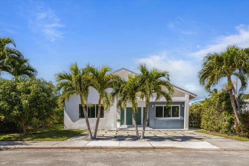 a white house with palm trees in front of it at Luxury House 4 beds heated Pool w Jaccuzzi in North Bay Village
