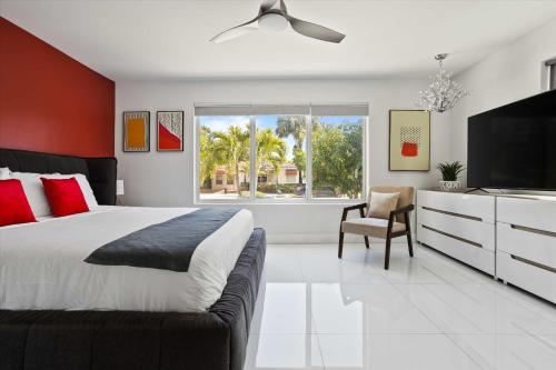 a bedroom with a large bed and a flat screen tv at Luxury House 4 beds heated Pool w Jaccuzzi in North Bay Village