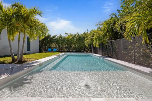 a swimming pool in a backyard with palm trees at Luxury House 4 beds heated Pool w Jaccuzzi in North Bay Village
