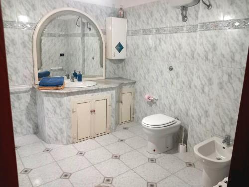 a bathroom with a sink and a toilet and a mirror at Casa di Roberto in Porto Cesareo