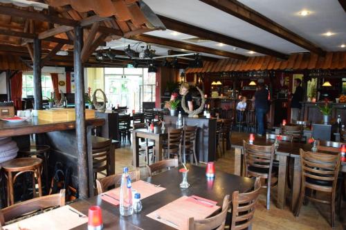 a restaurant with tables and chairs and a bar at Luxe Chalet met Veranda en Tuin , nabij Zwembad VP006 in Heinkensand