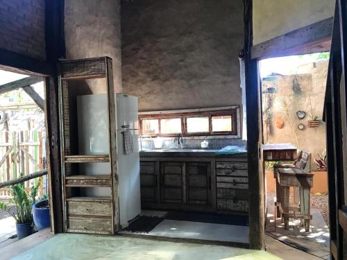 an open door to a kitchen with a refrigerator at Chalé João de barro in Bonito