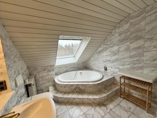 a bathroom with a bath tub and a sink at Sky Loft Schwarzach in Schwarzenbruck