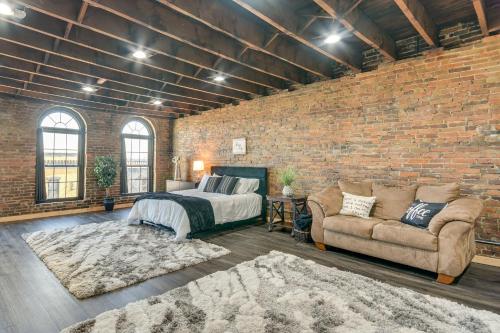a bedroom with a bed and a brick wall at Jacuzzi Tub & Full Kitchen: Dowtown Hannibal Loft in Hannibal