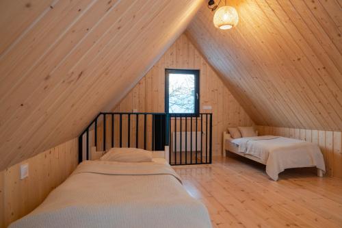 a attic room with two beds and a window at Siedlisko Gruszeczki in Gruszki