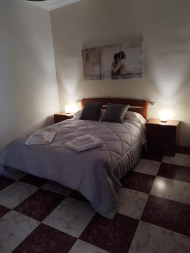 a bedroom with a large bed with two lamps at La Cañada in Baena