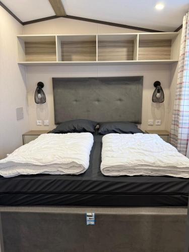 a bed with two white pillows on top of it at Het mooiste plekje van het park in Kropswolde