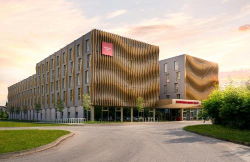 a building with a red sign on the side of it at Leonardo Royal Hotel Cologne Bonn Airport in Cologne