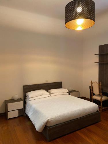 a bedroom with a bed with a lamp and a chair at Viva Accomodation in Bergamo