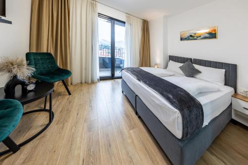 a bedroom with a bed and a chair and a window at Hotel MM Residence in Mostar