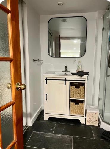 a bathroom with a white sink and a mirror at Studio moderne et tranquille in Montreal