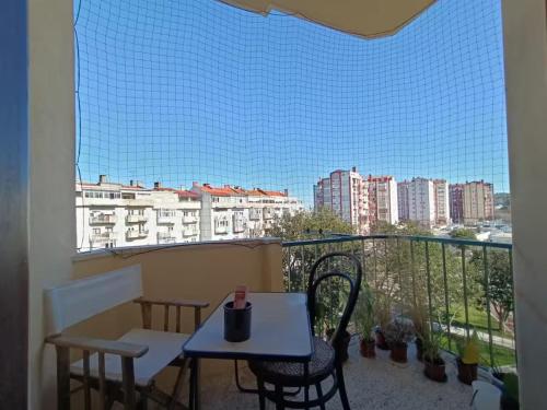 a balcony with a table and chairs and a view of a city at Amadora Pet Apartment in Amadora