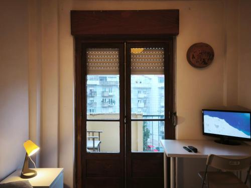 a door with a window and a computer on a desk at Amadora Pet Apartment in Amadora