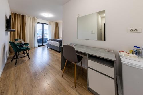 a room with a desk and a bedroom with a bed at Hotel MM Residence in Mostar