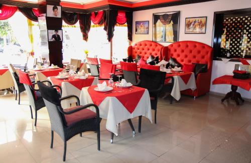 a restaurant with red tables and chairs in a room at New Farah Hotel in Agadir