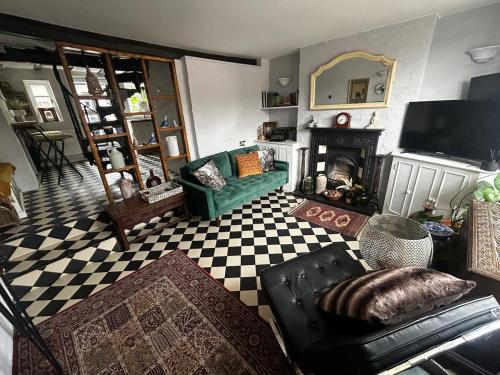 a living room with a green couch and a fireplace at Bewdley Riverside Cottage in Bewdley