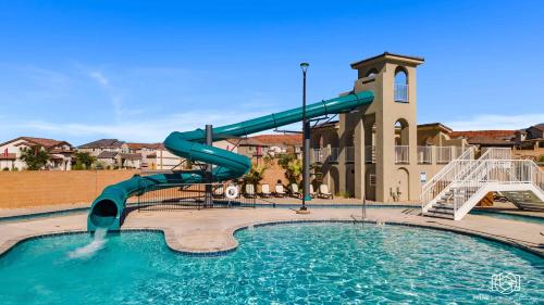 a water slide in a swimming pool in front of a building at Splash and Putt Paradise home in Washington