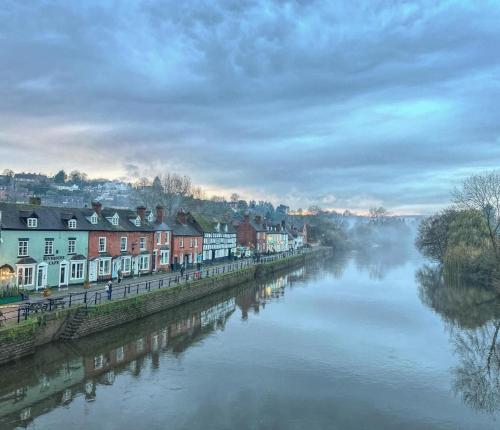 a view of a river with houses and buildings at Bewdley Riverside Cottage in Bewdley