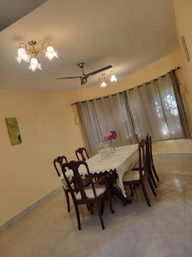 a dining room with a table and chairs and a window at AVIEL HOME in Accra