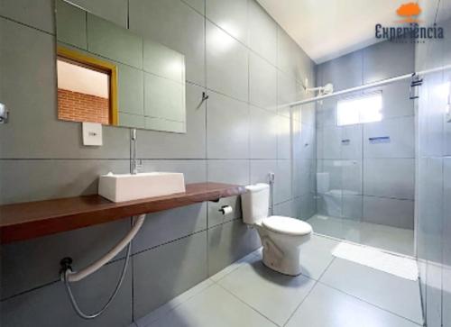 a bathroom with a toilet and a sink and a shower at Chácara Galileia in Trindade