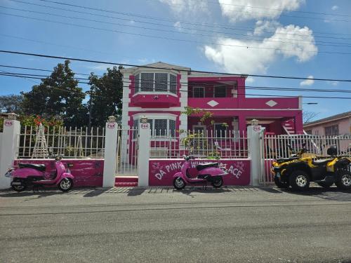 a pink house with scooters parked in front of it at Da Pink And White Palace in Nassau