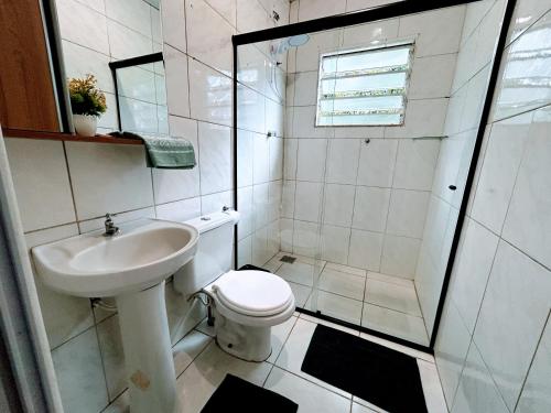 a bathroom with a toilet and a shower and a sink at Refúgio até 8 pessoas Churrasqueira e pátio cercado in Arroio do Meio