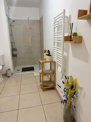 a bathroom with a shower and a toilet and a chair at T2 neuf Parking privé Balcon Plages à 15 min in Montpellier
