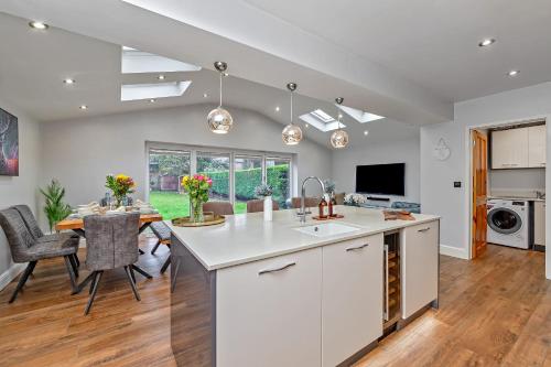 an open kitchen and dining room with a dining table at CONTRACTOR FRIENDLY-Large Driveway-THREE SMART TV's-Central Location-FOUR DOUBLE BEDROOMS in Luton
