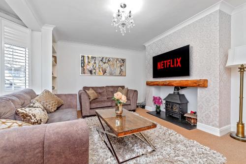 a living room with a couch and a fireplace at CONTRACTOR FRIENDLY-Large Driveway-THREE SMART TV's-Central Location-FOUR DOUBLE BEDROOMS in Luton