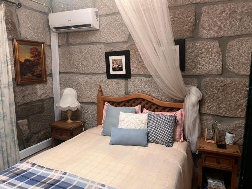 a bedroom with a bed with pillows on it at Casa da Costinha in Cinfães