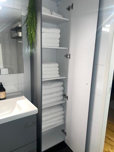 a bathroom with a sink and a stack of towels at My Home Kaldfjorden in Tromsø
