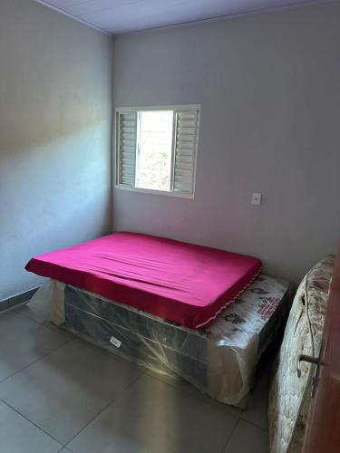 a large pink bed in a room with a window at Rancho Patrocínio in Patrocínio