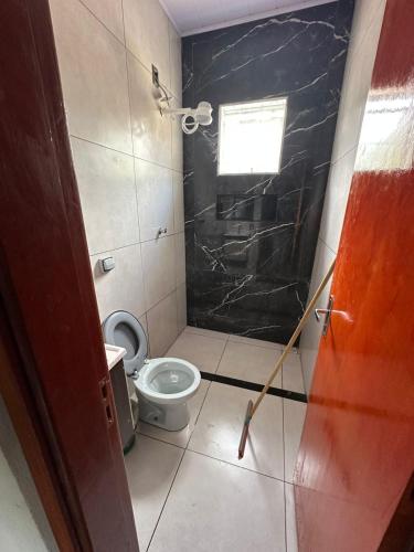a small bathroom with a toilet and a window at Rancho Patrocínio in Patrocínio