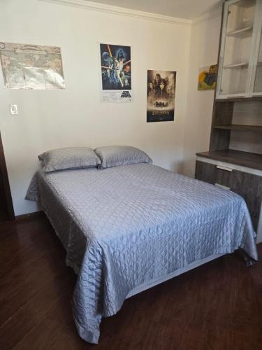 a bedroom with a bed with a blue comforter at Premium house with pool in Santana do Livramento