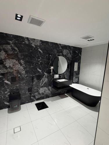 a bathroom with a tub and a sink and a mirror at فيلا شاليه ذا ويسس in Taif