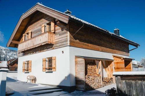 an old wooden house with a horse in front of it at Almdorf Katschberg in Katschberghöhe