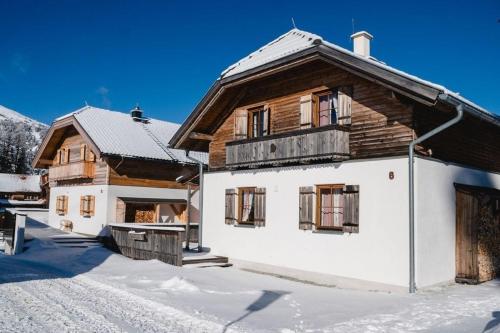 a wooden house with snow on the ground at Almdorf Katschberg in Katschberghöhe