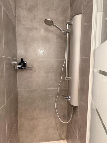 a shower with a shower head in a bathroom at L'atelier Terracotta centre ville Bethune in Béthune