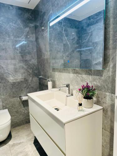 a bathroom with a sink and a toilet and a mirror at Whispering Waves at Mercury Tower with panoramic view , 2X pools and Gym in Paceville
