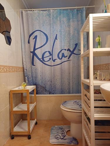 a bathroom with a toilet and a shower curtain at Mona Baltico-Traveller Awards 2026 in Torrevieja