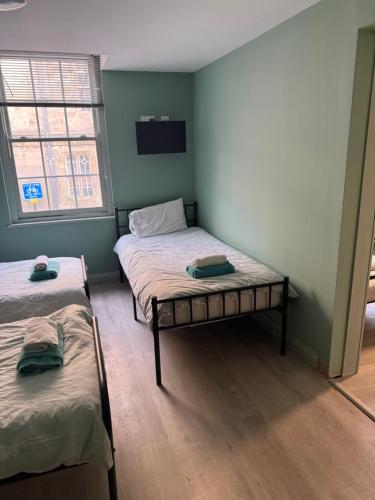 ein Zimmer mit zwei Betten und einem Fenster in der Unterkunft Tumbledown Hotel in Shrewsbury