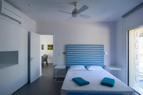 a bedroom with a bed with two blue pillows on it at Lavender Cove in Korfos