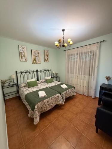 a bedroom with a bed with green pillows on it at La Huerta del Rodeo in Navas de San Antonio