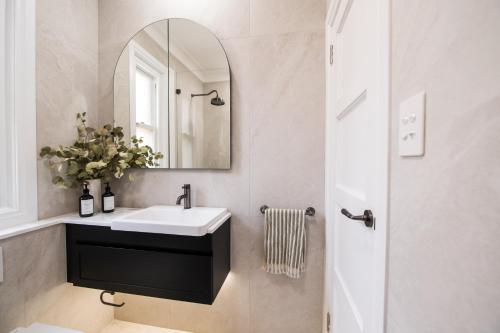 a bathroom with a sink and a mirror at Manly Waterfront Apartment Harbourside in Sydney