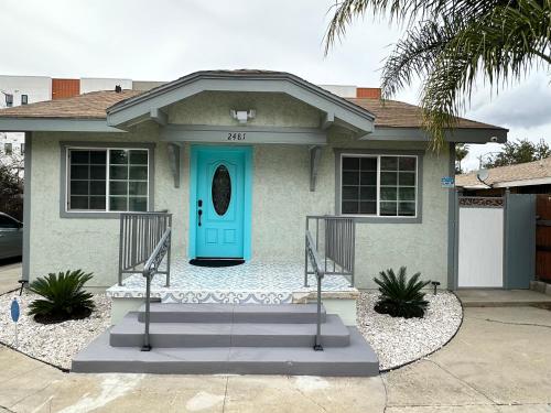 a house with a turquoise door and stairs at Coastal Calm Casita in Long Beach