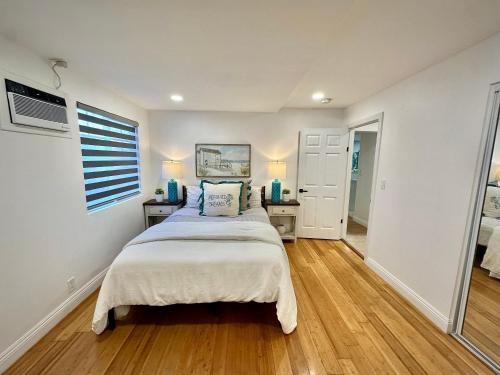 a bedroom with a bed and two night stands and a window at Coastal Calm Casita in Long Beach