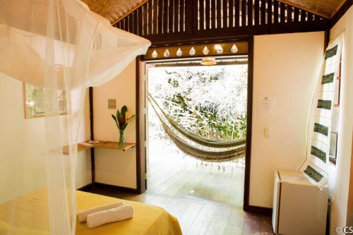 um quarto com uma cama e uma grande janela em Pousada Too Cool em Diogo