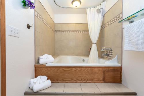 a bathroom with a bath tub with a shower curtain at Cascade Motel in Oakridge