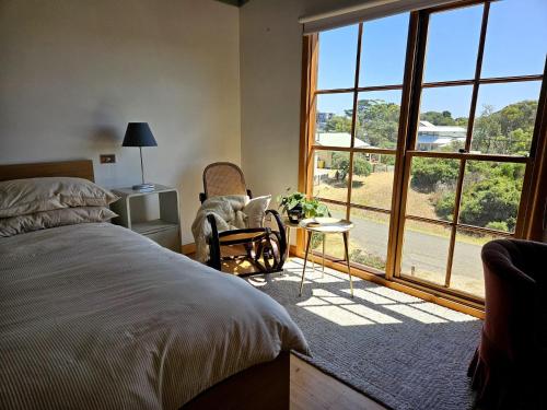 a bedroom with a bed and a large window at Cedar Hill Retreat in Venus Bay